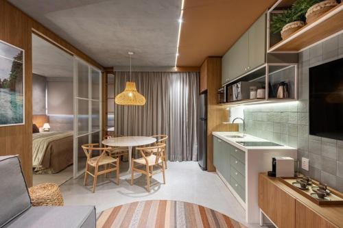 a kitchen and living room with a table and a bedroom at Studio Bali, aconchego e luxo. in Campo Grande