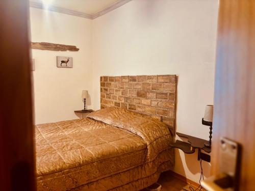 a bedroom with a bed and a brick wall at Romeo House in Campo di Giove