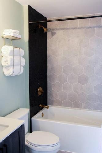a bathroom with a toilet and a tub and a sink at Romantic Waterfront Sunset Views in PEC in Belleville