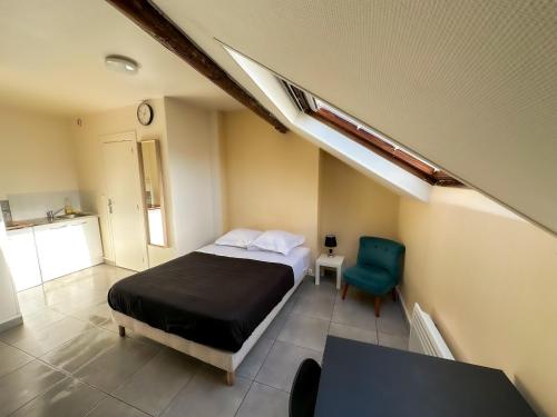 a bedroom with a bed and a blue chair at Studio SN7 - Centre-Ville Meaux - Proche Disneyland in Meaux