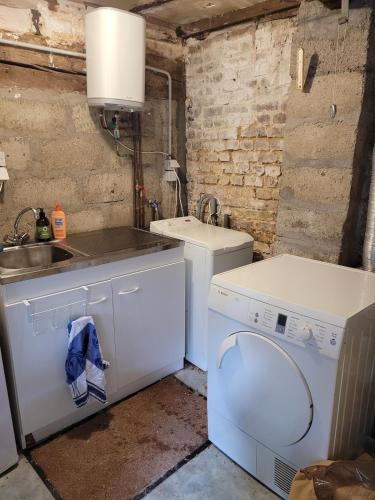 - une buanderie avec un évier et un lave-linge dans l'établissement Authentique Maison Normande de village, à Cormeilles