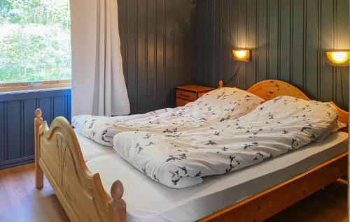 a bedroom with a bed with a white comforter at Gorgeous Home In Øydegard With Wifi in Aspa