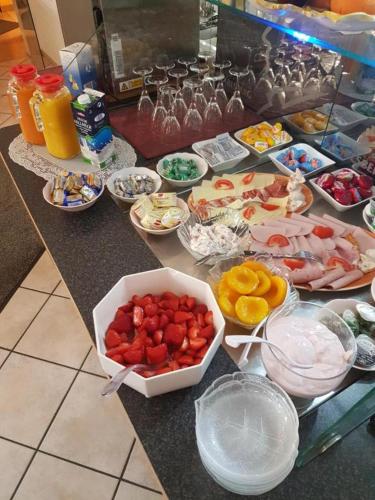 a counter with many bowls of food on it at Hotel Schweizer Stubb in Kaiserslautern