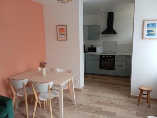 une cuisine et une salle à manger avec une table et des chaises dans l'établissement Maison paisible, à Fécamp