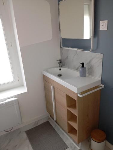 une salle de bain avec un lavabo et un miroir dans l'établissement Maison paisible, à Fécamp