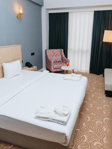 a hotel room with a bed and a chair at CONGRESS Hotel in Baku