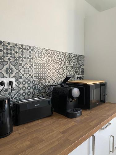 a room with a desk and a computer on a wall at L'écrin vert - Wifi - Netflix - Climatisation - Parking Gratuit in Périgueux