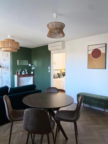 a living room with a table and chairs and a bed at L'écrin vert - Wifi - Netflix - Climatisation - Parking Gratuit in Périgueux