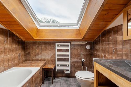 La salle de bains est pourvue d'une lucarne, de toilettes et d'un lavabo. dans l'établissement Chalet Les Charmilles - Vallée de Chamonix - 5 chambres, aux Houches