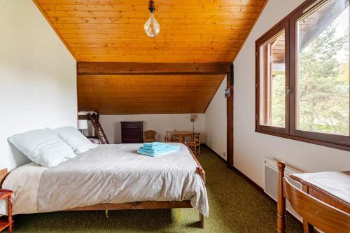 une chambre avec un lit et un plafond en bois dans l'établissement Chalet Les Charmilles - Vallée de Chamonix - 5 chambres, aux Houches