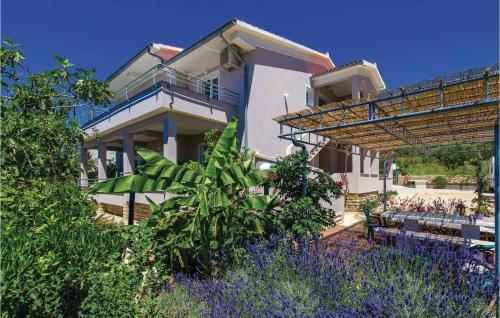 a house with a garden with purple flowers at 1 Bedroom Beautiful Apartment In Barbat in Barbat na Rabu