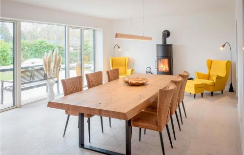 a dining room with a wooden table and yellow chairs at Haus Hilda in Grömitz