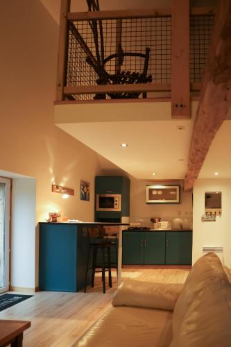 un salon avec un canapé et une cuisine dans l'établissement LOFT Le chant des Oiseaux proche Mont St Michel, à Pleine-Fougères