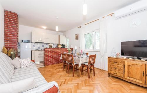 a kitchen and living room with a table and chairs at Awesome Home In Unesic in Unešić