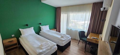 two beds in a room with a green wall at Къща за гости ЕСТЕТ ESTET Guest house in Oreshak