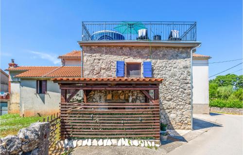 a stone house with a balcony on top of it at 2 Bedroom Cozy Home In Malinska in Malinska