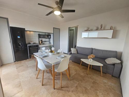 Face à la mer appartement vue mer Portiragnes plage proche Cap d'agde Vias Valras-plage Méditérranée في بورتيراني: غرفة معيشة بها أريكة وطاولة