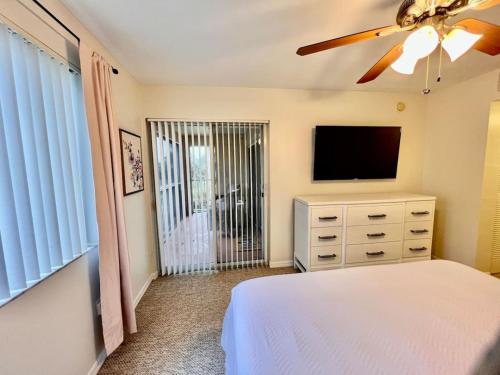a bedroom with a bed and a flat screen tv at Beach More Getaway in Vero Beach