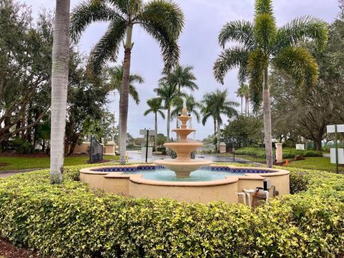 a fountain in a park with palm trees at Beach More Getaway in Vero Beach