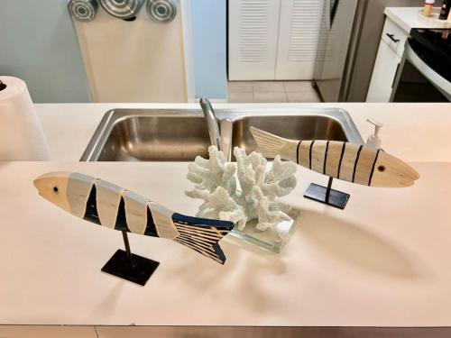 two wooden fish on a counter in a sink at Beach More Getaway in Vero Beach