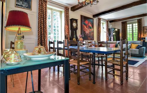 une salle à manger avec une table et des chaises bleues dans l'établissement Amazing Home In Sernhac With Wifi, à Sernhac