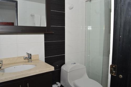bagno con servizi igienici, lavandino e specchio di Colombia Real Hotel a Barrancabermeja