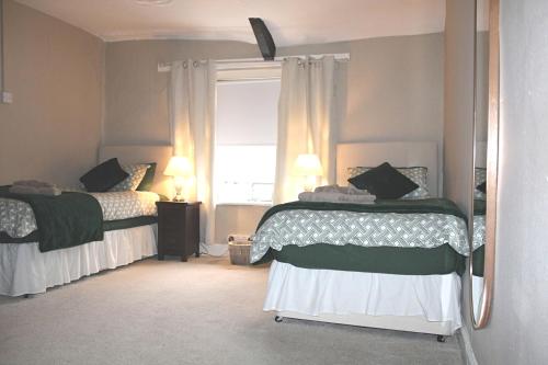 a bedroom with two beds and a window at The Swan in Thornbury