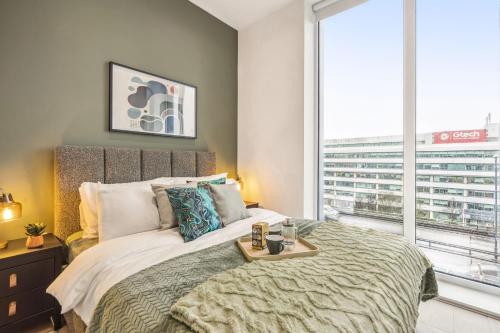a bedroom with a large bed and a large window at Ultra-Luxury Modern Apartment with Gym, Cinema, Game Room and Parking in Kew Bridge