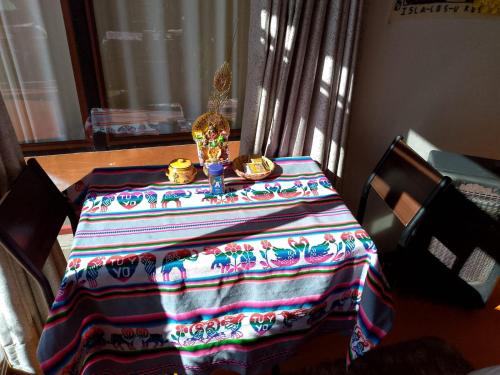 a table with a colorful table cloth on top of it at Uros TITIKAKA the Best lodge in Puno