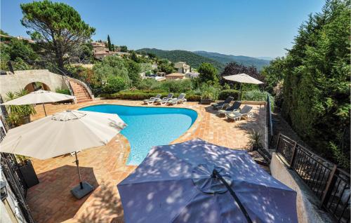 a swimming pool with umbrellas and chairs at Awesome Home In Les Adrets D L'estérel in St Jean de l’Esterel