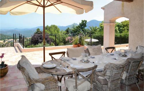 a table with chairs and an umbrella on a patio at Awesome Home In Les Adrets D L'estérel in St Jean de l’Esterel