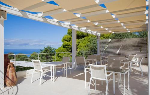 patio ze stołami i krzesłami oraz widokiem na ocean w obiekcie Pet Friendly Apartment In Ricadi w mieście Ricadi