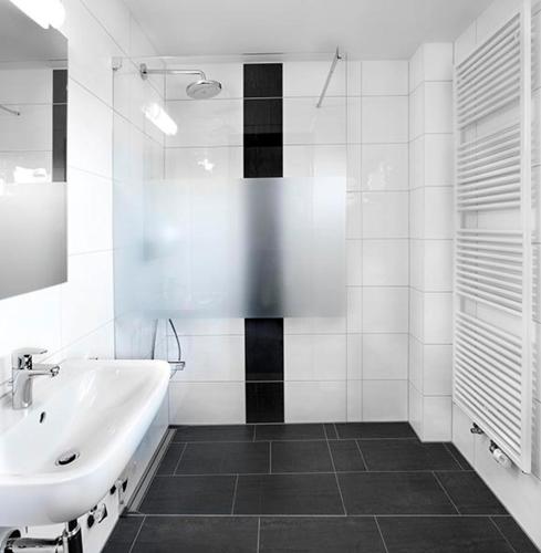 a white bathroom with a sink and a tub at Das Gästehaus Eimeldingen in Eimeldingen