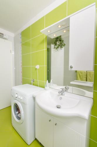 a bathroom with a washing machine and a sink at Studios Anna in Rovinj
