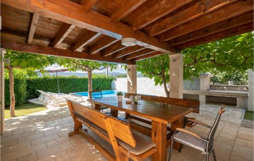 a wooden table and chairs under a wooden pergola at Amazing Home In Vinjani Donji in Imotski