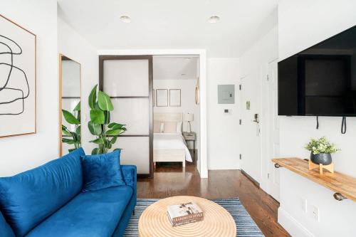a living room with a blue couch and a table at 69-3B Celebrate in Style 1BR Prime Lower East Side Brand New in New York