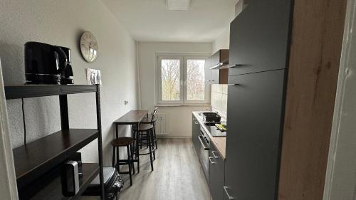 a small kitchen with a refrigerator and a table at MiCasa TuCasa - 3-R Apartment Leipziger Neuseenland Nova in Kitzscher