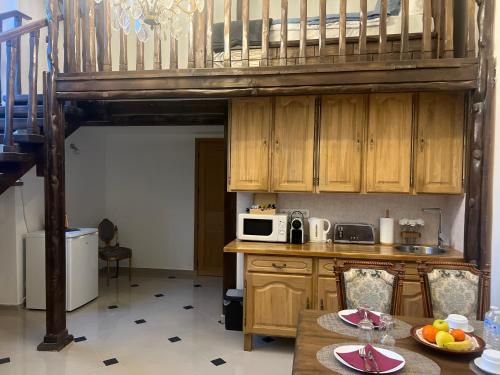 a kitchen with a loft with a microwave and a table at Château de Crenille -Appartements in Chaumes-en-Brie