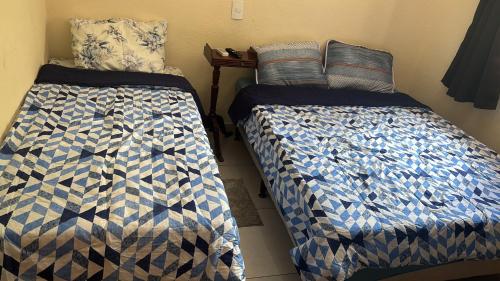 deux lits côte à côte dans une pièce dans l'établissement Casa Central, à Serra Negra