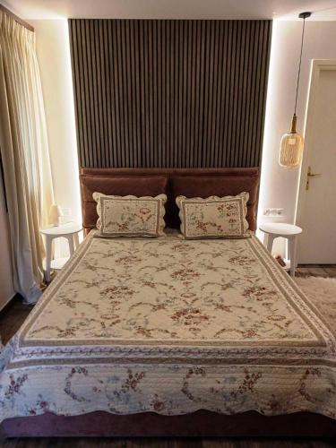 a bedroom with a large bed with two tables at GOURA House in Metsovo