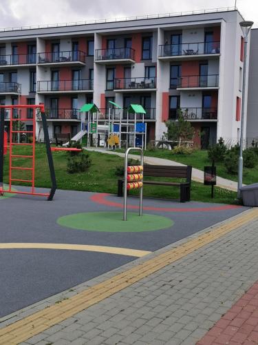 a playground in front of a large apartment building at Ragaines apartamentai self check-in in Klaipėda