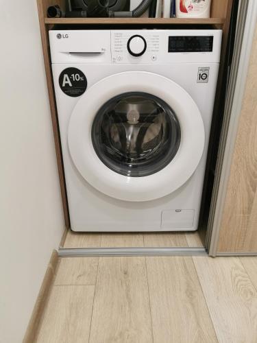 a washing machine is in a cabinet in a room at Ragaines apartamentai self check-in in Klaipėda