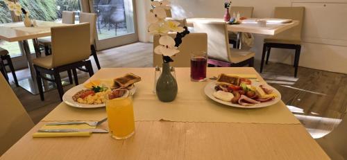 een tafel met twee borden eten en een glas sinaasappelsap bij Apartment Draco in Harrachov