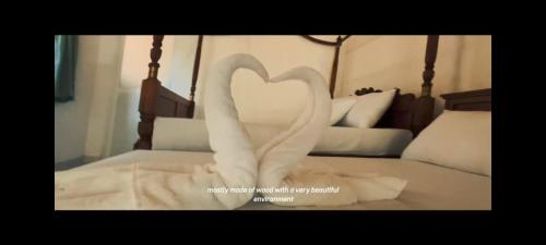 a pair of swans forming a heart on a bed at Golden Leaf Rainforest Eco Village in Nugadanda