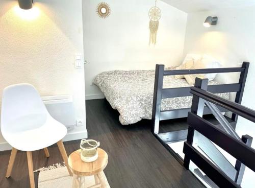 une petite chambre avec un lit et une chaise dans l'établissement Duplex vue Mer Royan, à Royan