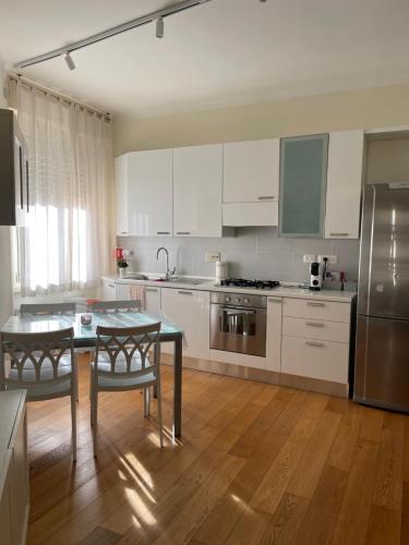 una cucina con mobili bianchi e un tavolo con sedie di Casetta via delle Cave a Roma