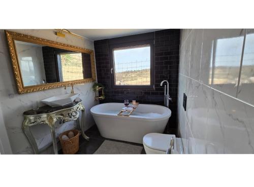 a bathroom with a tub and a sink and a toilet at Aquarius Luxury Suites in Ólimbos