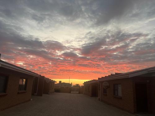 a sunset in the sky over a street with buildings at Paresis 7 in Hentiesbaai