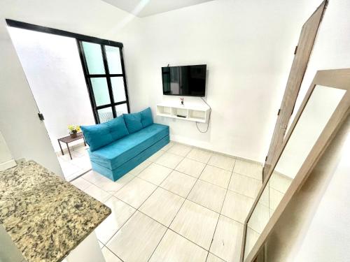 a living room with a blue couch and a tv at Lindo APT 05 em bairro central de Petrolina em prédio familiar in Petrolina