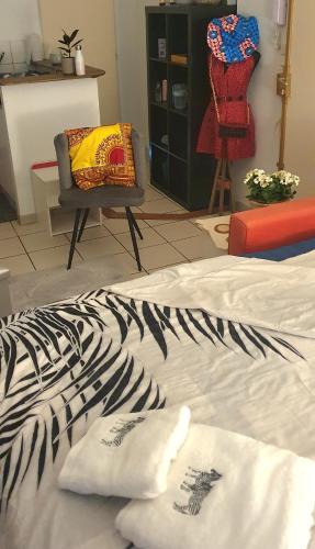- un lit dans une chambre avec une chaise et un canapé dans l'établissement Studio cosy 33, à Bassens